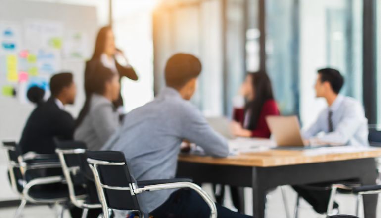 Délégués médicaux en session de formation, assis autour d'une table présidée par le formateur